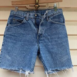 Levi’s blue denim shorts, front pockets, zipper closure, hem fringes, 25